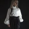 Relaxed fit shirt with stand collar, press stud asymmetrical fastening and double gathered bishop sleeves.