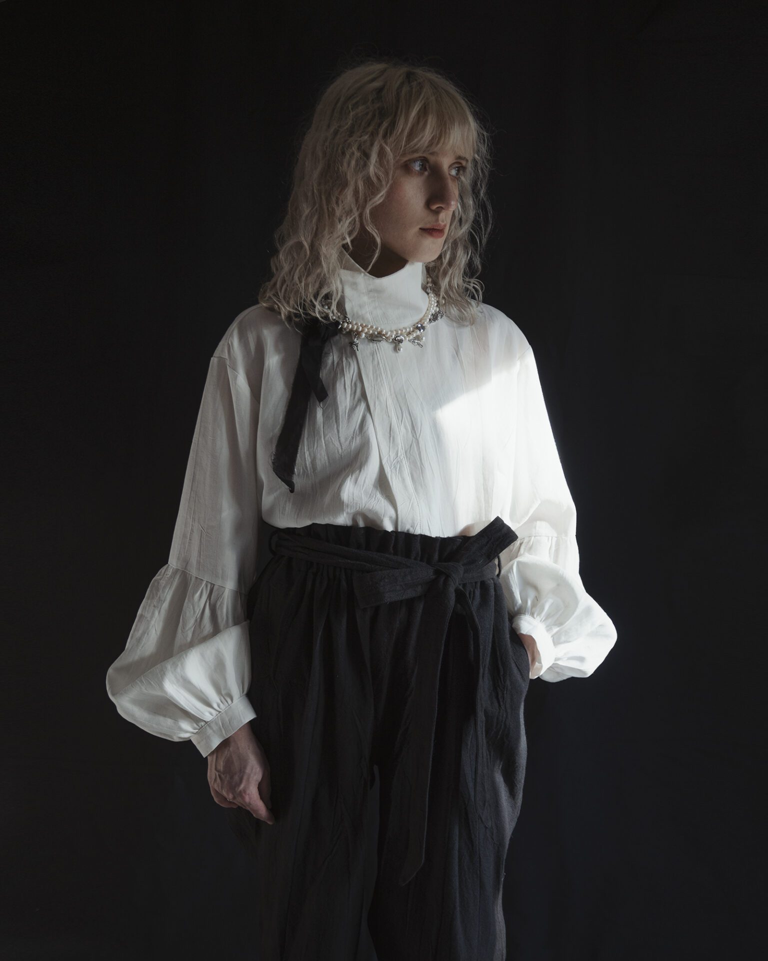 Relaxed fit shirt with stand collar, press stud asymmetrical fastening and double gathered bishop sleeves.