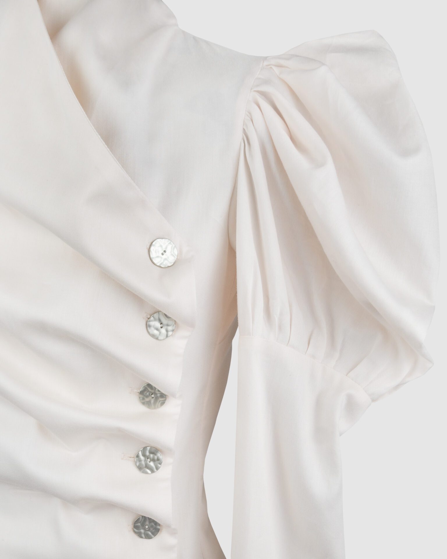 Cotton satin fitted blouse with a draped front and voluminous sleeves.