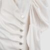 Cotton satin fitted blouse with a draped front and voluminous sleeves.