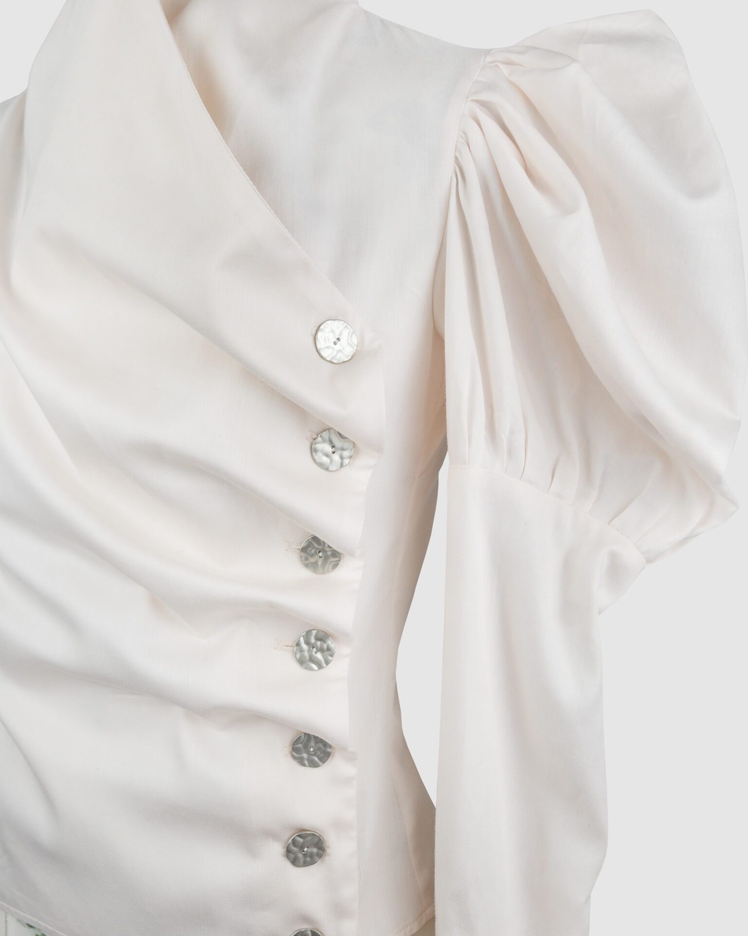 Cotton satin fitted blouse with a draped front and voluminous sleeves.