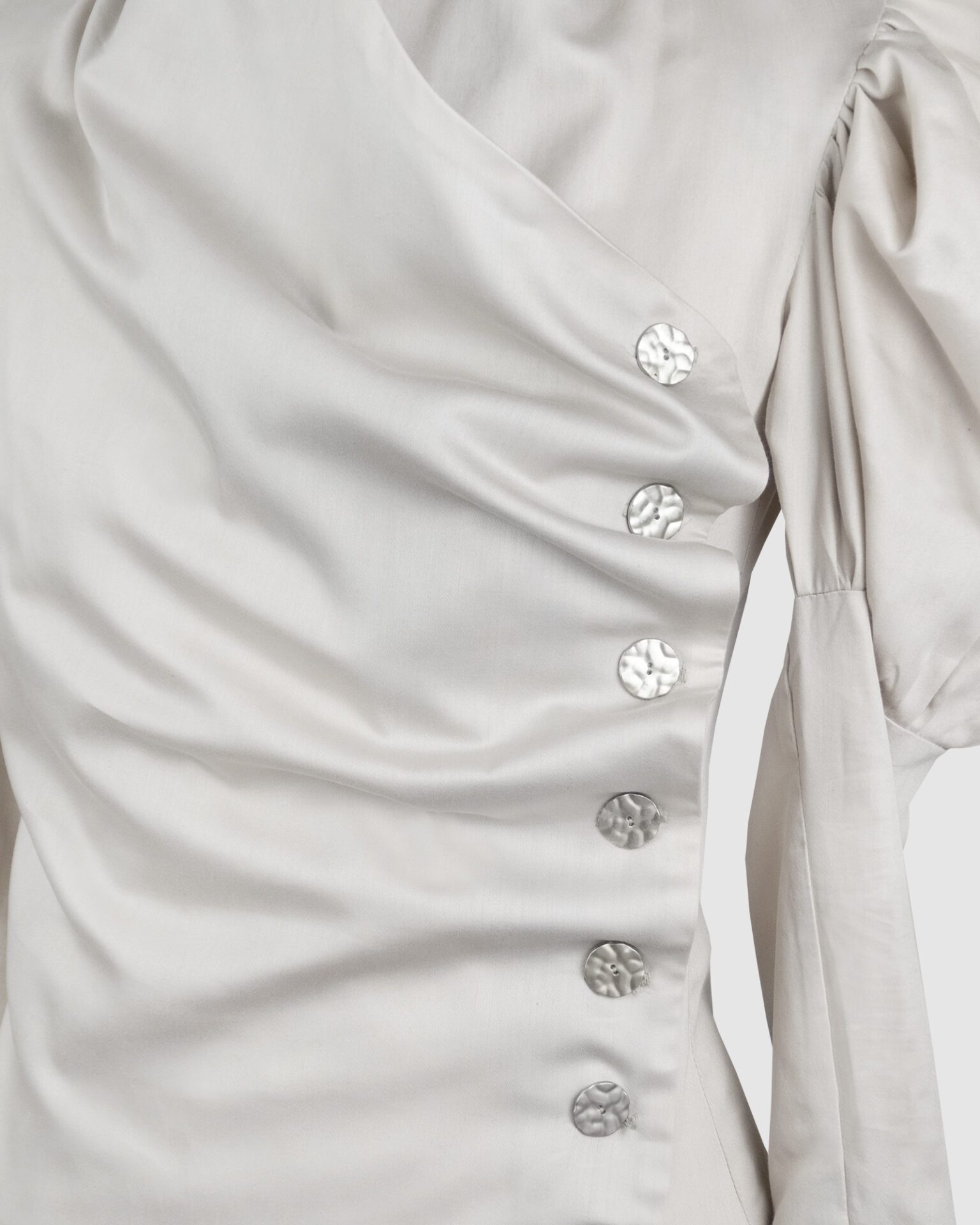 Cotton satin fitted blouse with a draped front and voluminous sleeves.