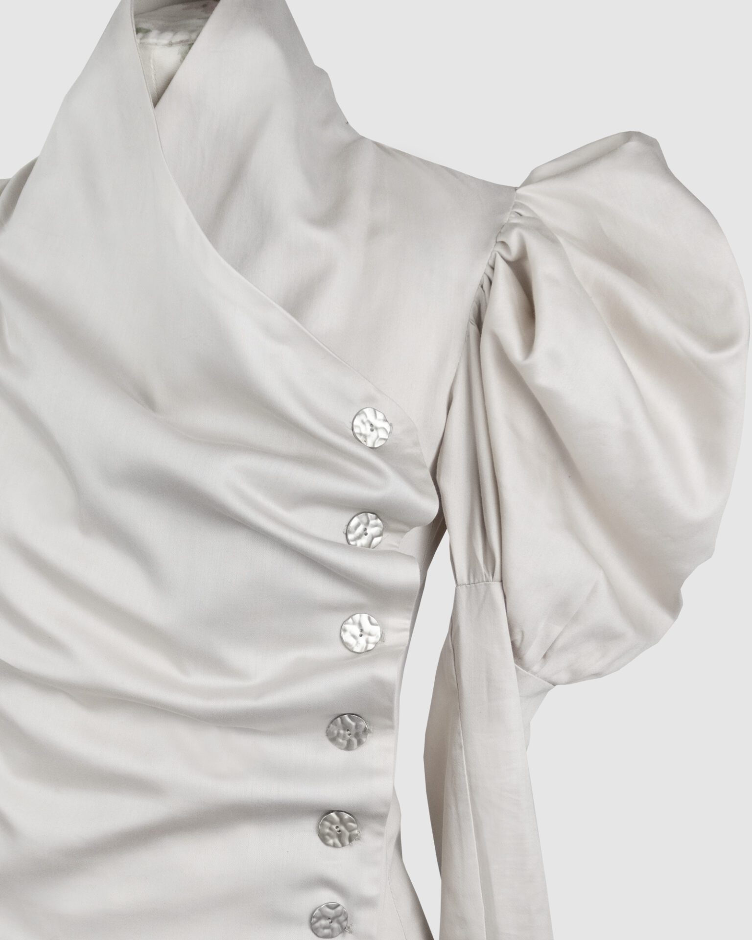 Cotton satin fitted blouse with a draped front and voluminous sleeves.