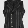 The long, fitted vest features a stand collar, a welt breast pocket, and pockets with pointed flaps.