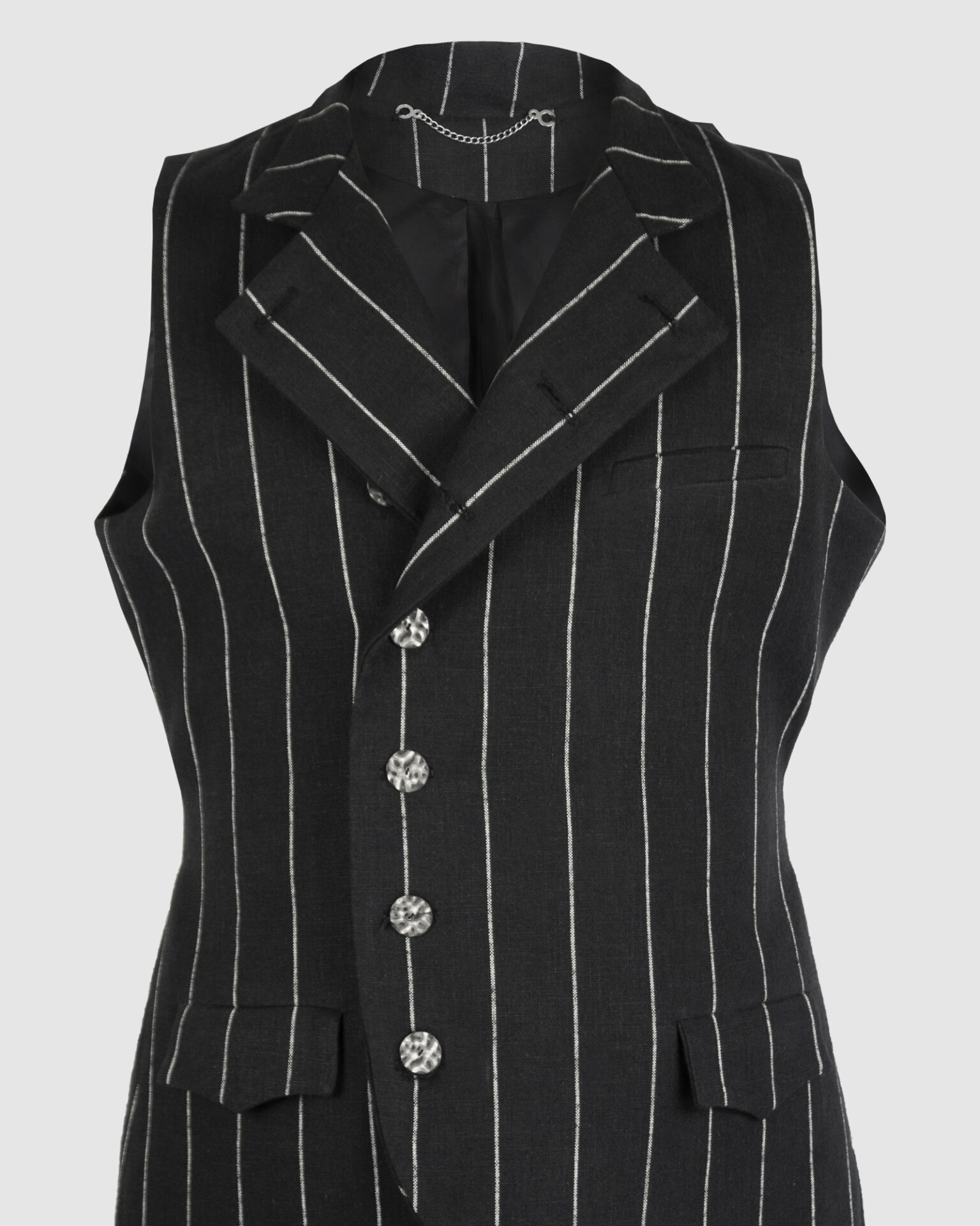 The long, fitted vest features a stand collar, a welt breast pocket, and pockets with pointed flaps.