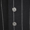 The long, fitted vest features a stand collar, a welt breast pocket, and pockets with pointed flaps.