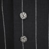 The long, fitted vest features a stand collar, a welt breast pocket, and pockets with pointed flaps.