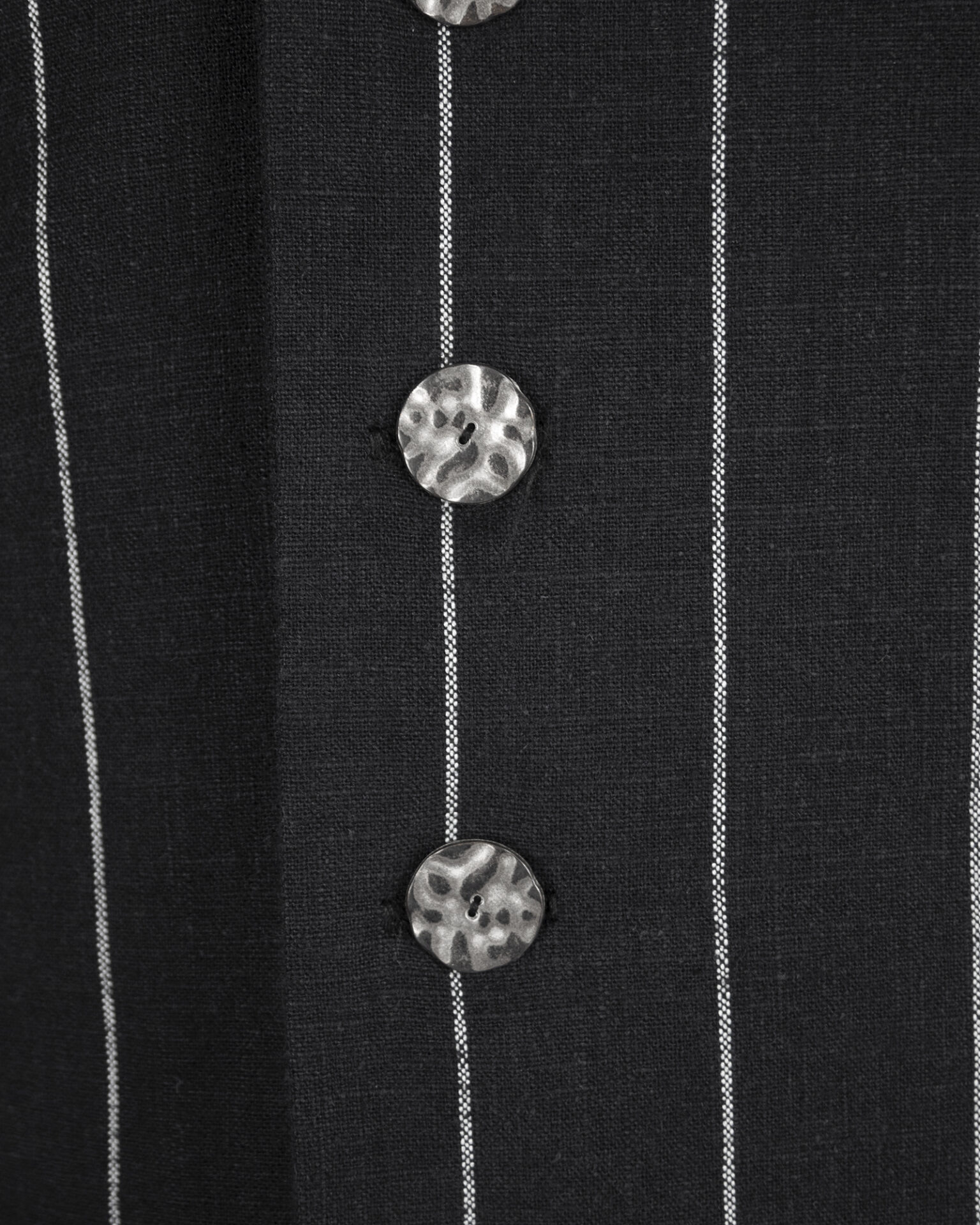 The long, fitted vest features a stand collar, a welt breast pocket, and pockets with pointed flaps.