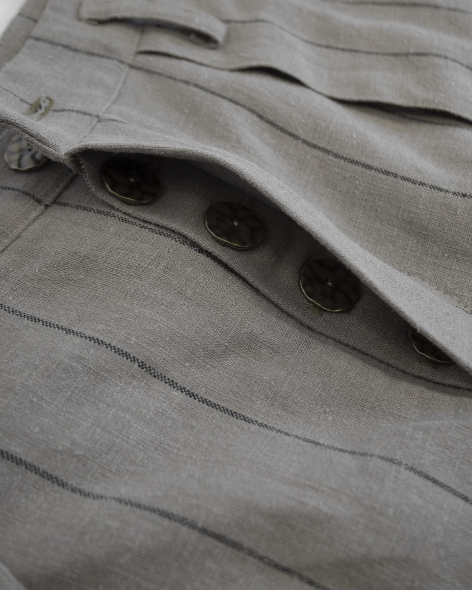 Regular rise, wide leg trousers. The front features a hidden metal button fastening, overlapping architectural pleats, and slash pockets.