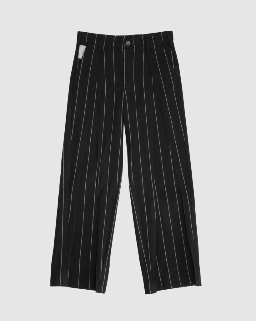 Regular rise, wide leg trousers. The front features a hidden metal button fastening, overlapping architectural pleats, and slash pockets.