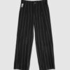 Regular rise, wide leg trousers. The front features a hidden metal button fastening, overlapping architectural pleats, and slash pockets.