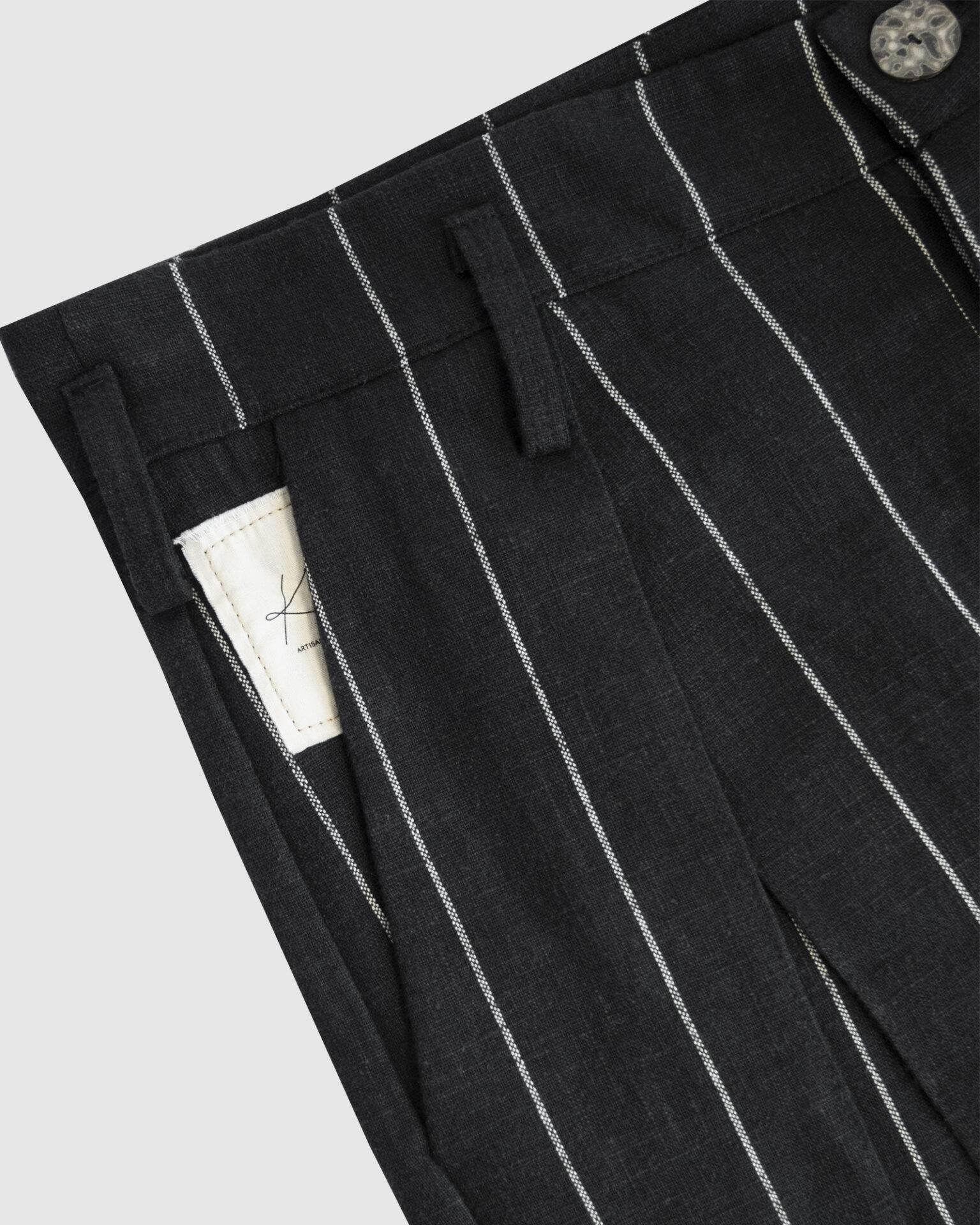 Regular rise, wide leg trousers. The front features a hidden metal button fastening, overlapping architectural pleats, and slash pockets.