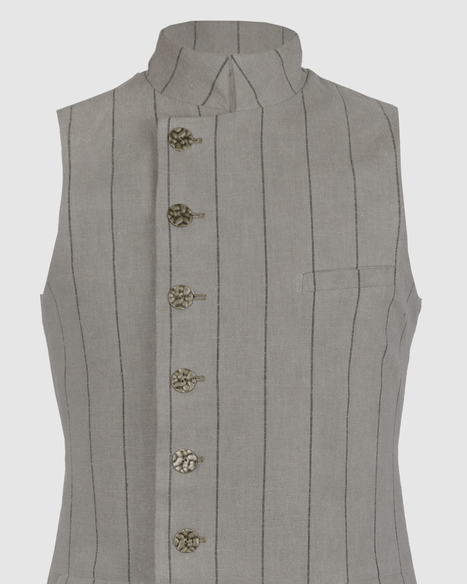 The long, fitted vest features a stand collar, a welt breast pocket, and pockets with pointed flaps.