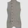 The long, fitted vest features a stand collar, a welt breast pocket, and pockets with pointed flaps.