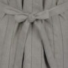 The long, fitted vest features a stand collar, a welt breast pocket, and pockets with pointed flaps.