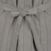 The long, fitted vest features a stand collar, a welt breast pocket, and pockets with pointed flaps.