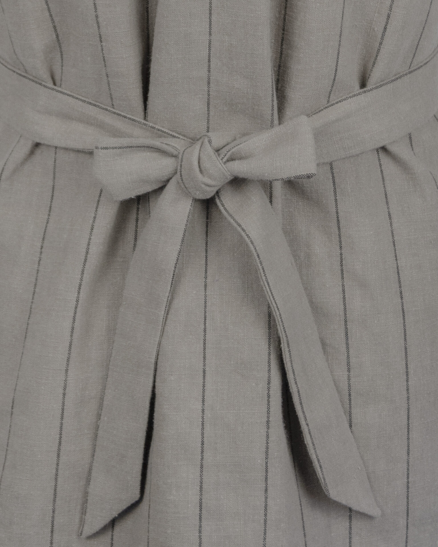 The long, fitted vest features a stand collar, a welt breast pocket, and pockets with pointed flaps.