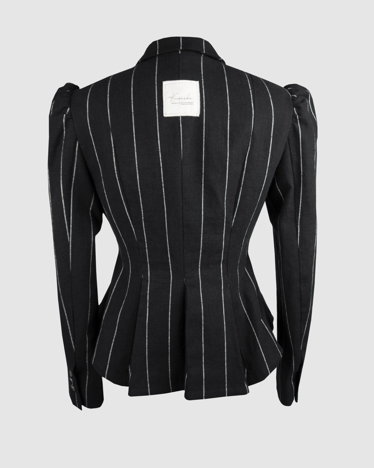 Fitted, single-breasted cotton velvet jacket with narrow peak lapels, released tucks at the waist, side seam pockets, and a softly pointed front hem.
