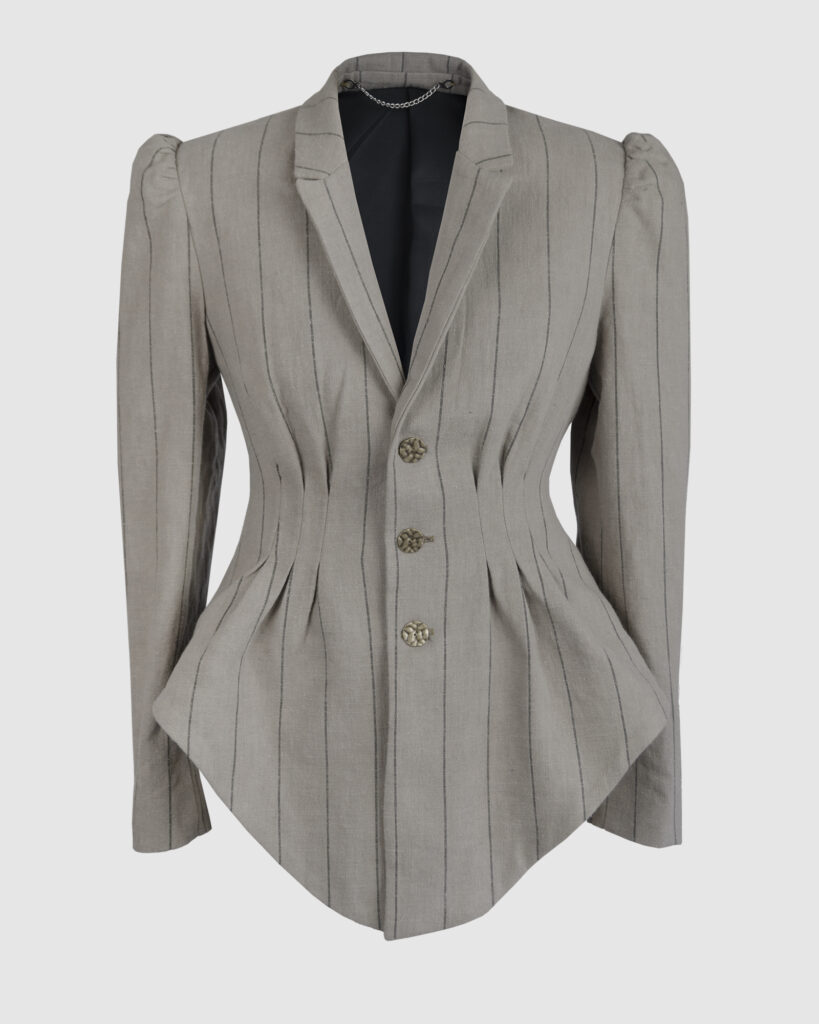 Fitted, single-breasted cotton velvet jacket with narrow peak lapels, released tucks at the waist, side seam pockets, and a softly pointed front hem.