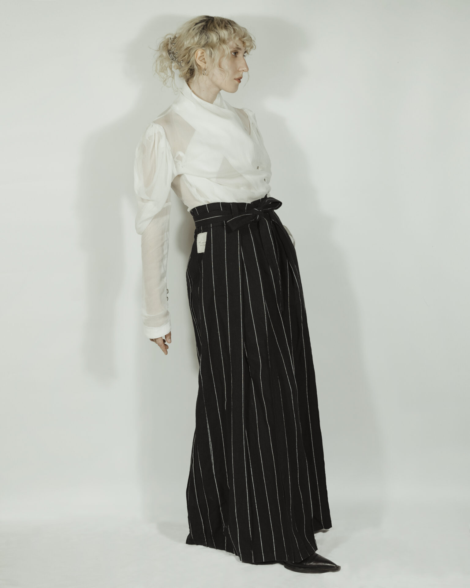 Fitted blouse with a draped front and voluminous sleeves The piece is inspired by traditional Japanese hakama trousers. It is a pair of wide-legged trousers with a high waistband.