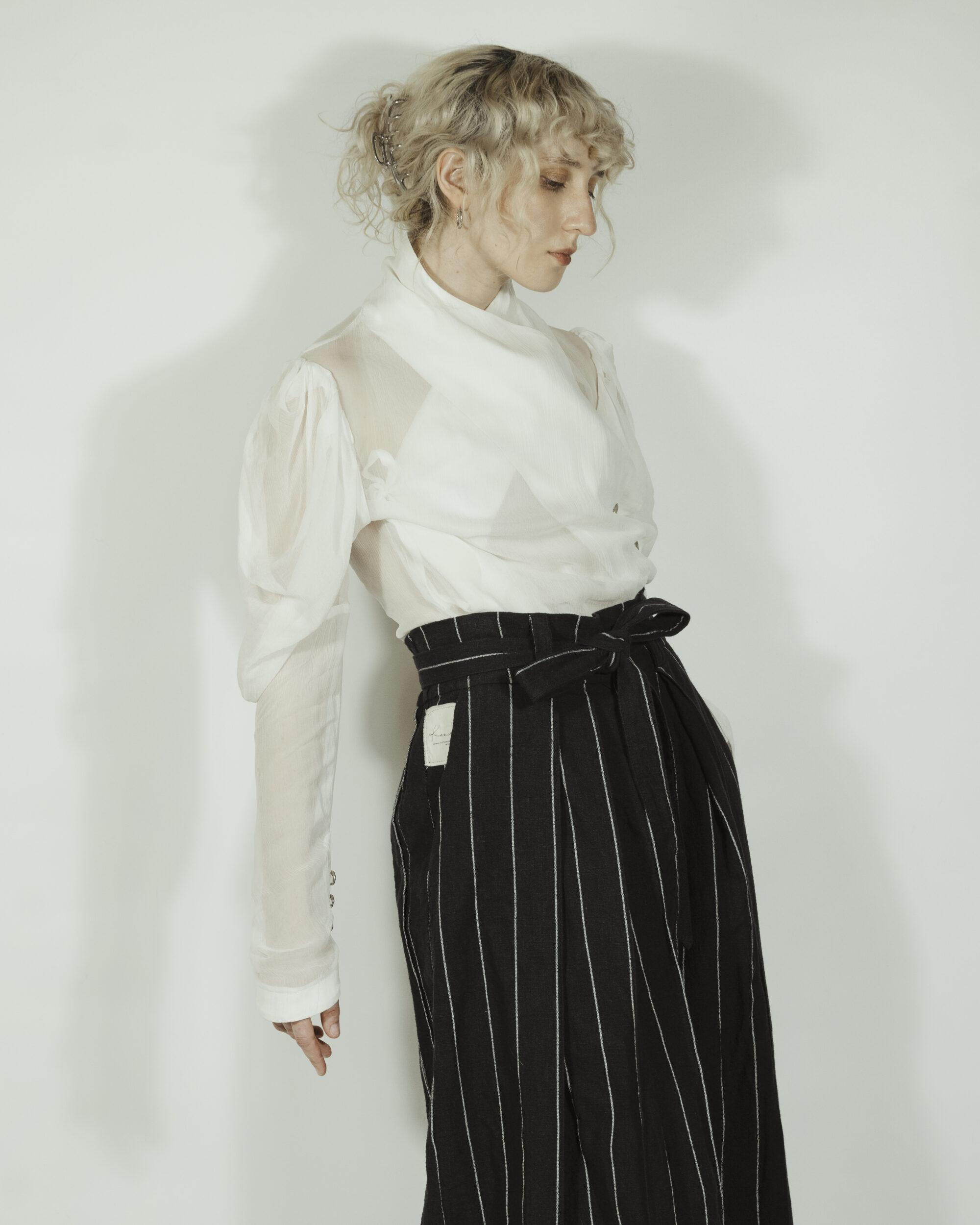 Fitted blouse with a draped front and voluminous sleeves The piece is inspired by traditional Japanese hakama trousers. It is a pair of wide-legged trousers with a high waistband.