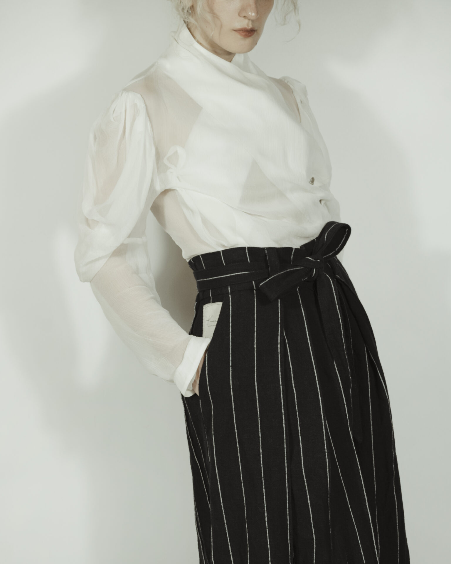 Fitted blouse with a draped front and voluminous sleeves The piece is inspired by traditional Japanese hakama trousers. It is a pair of wide-legged trousers with a high waistband.