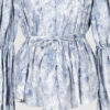 This loose-fitting blouse features a softly pointed front hem, a stand collar accented with a short ruffle, and a front button closure.