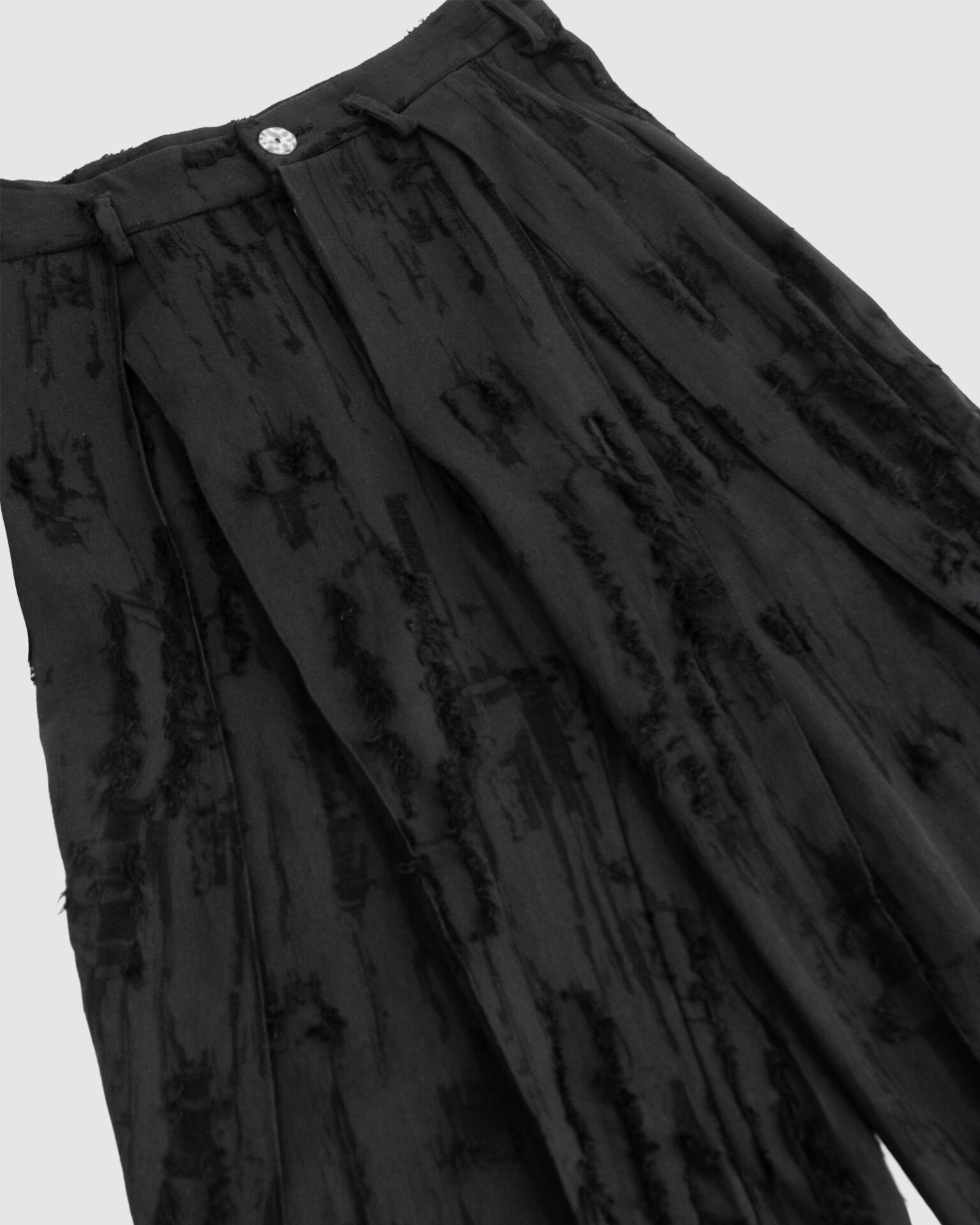 Trousers with overlapping pleats